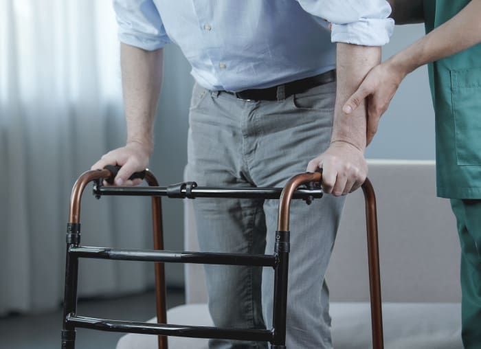 Nurse assited the man with walking frame