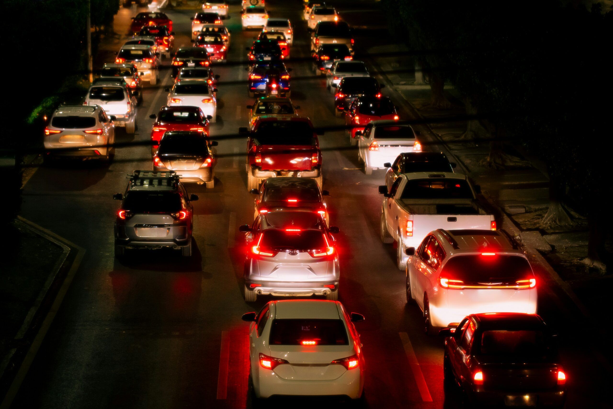 a crowded highway at night with lots of brake lights showing