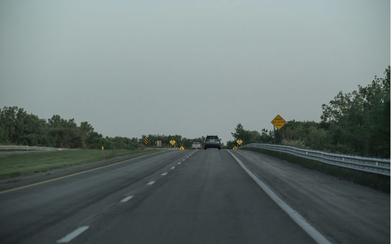 a highway at dusk with few cars on it