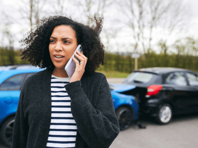 Woman calling emergency services after a car accident