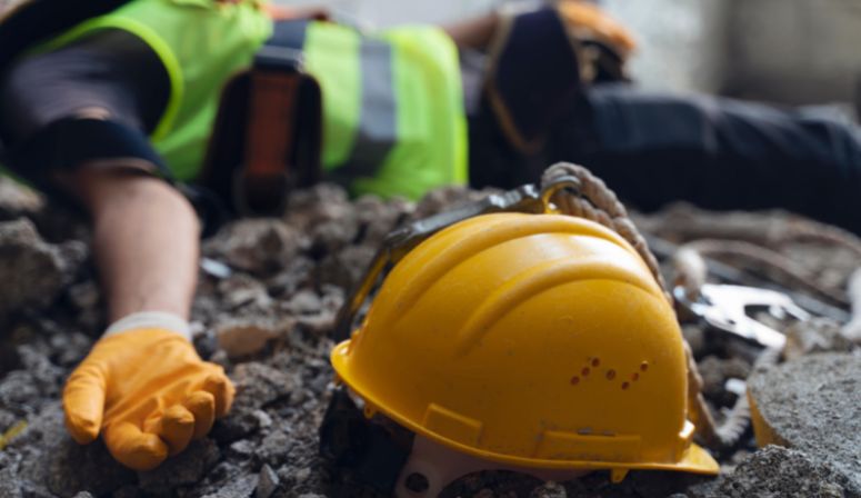 Construction worker laying next to hard hat
