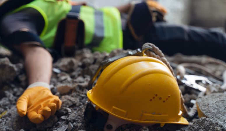 Construction worker laying next to hard hat