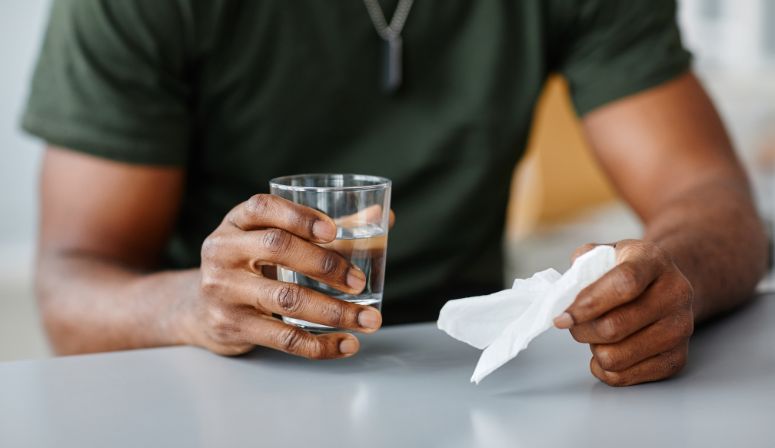 Man sitting down holding a glass of water