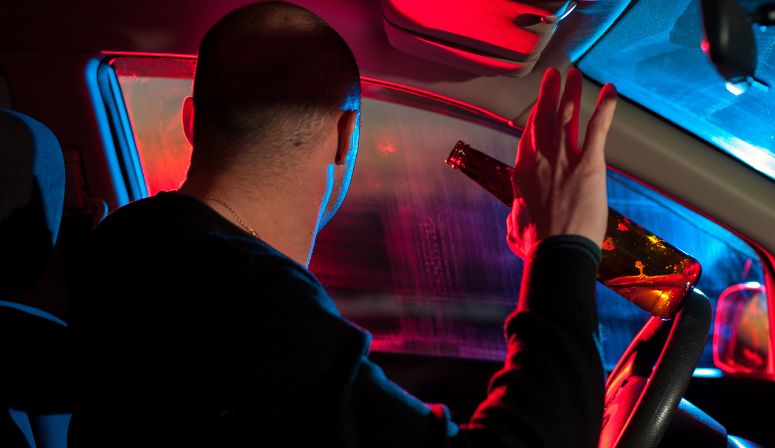 man holding hands up in car