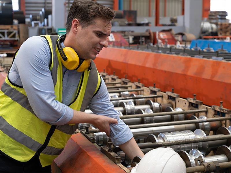 distressed factory worker with his hand stuck in a machine