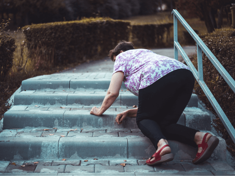 Elderly woman slipping while walking up a set of stairs