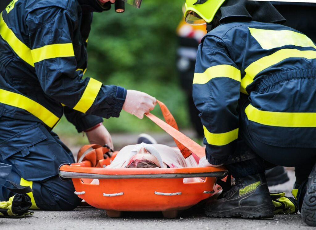 Un hombre tumbado en una camilla tras un accidente, mientras los servicios de rescate se encuentran allí