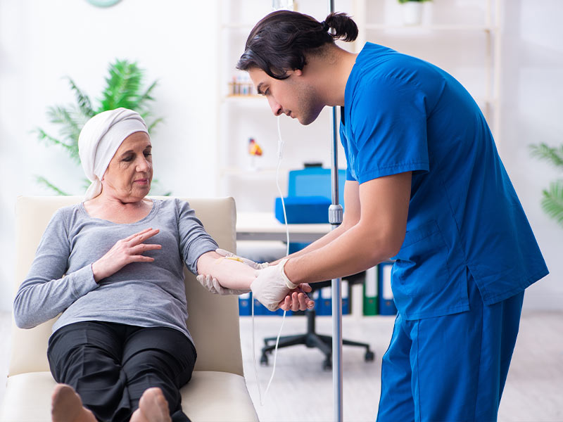 nurse inserting an IV into a female patients arm