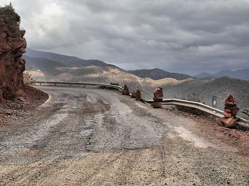 dirt highway with damage to the guardrails from landslides