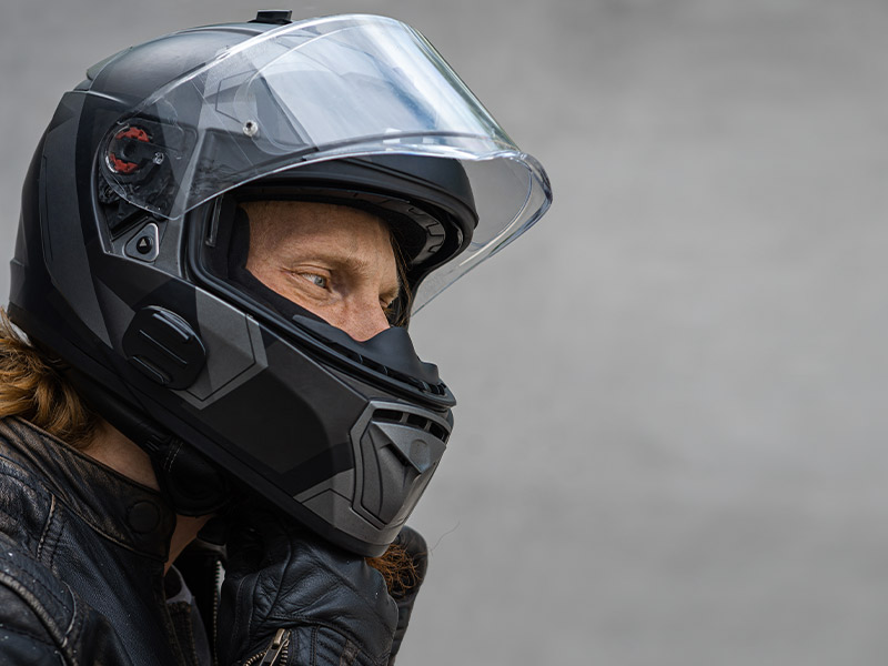 man tightening the chin strap to his helmet