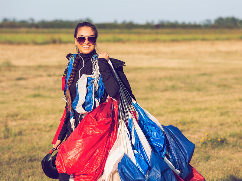 Female skydiver standing with her parachute 