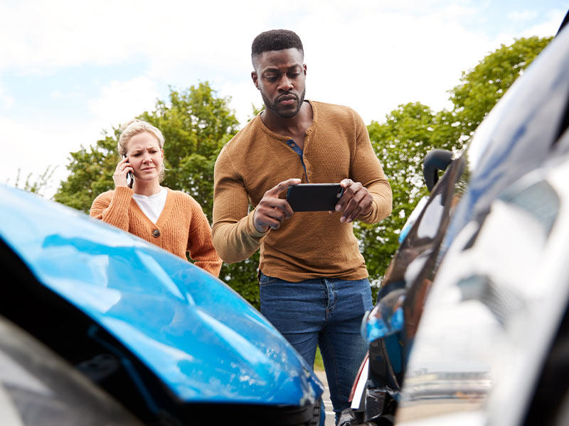 a man taking pictures of a car accident