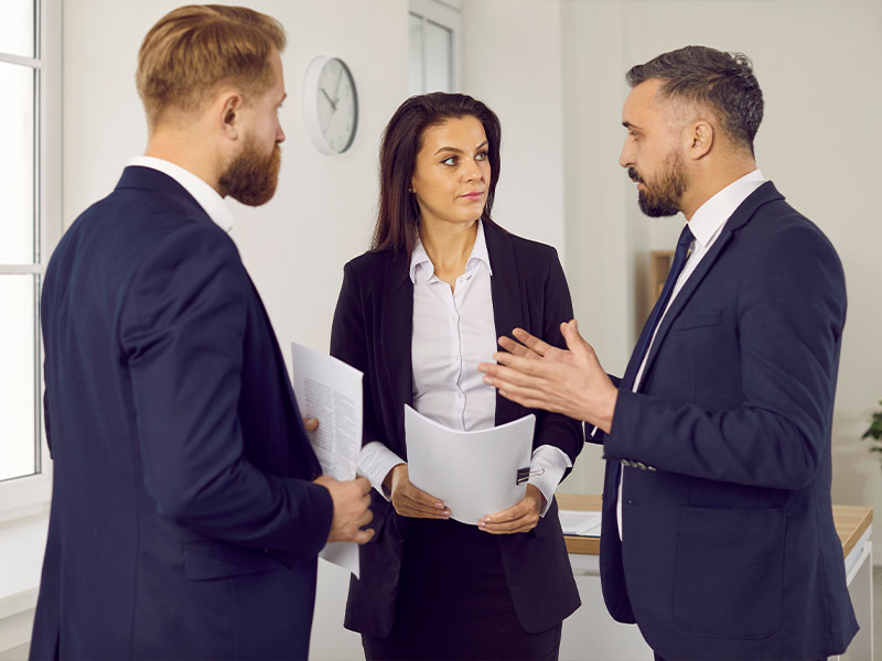 three lawyers standing in a circle talking