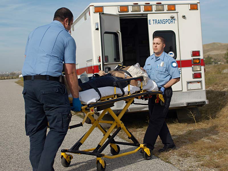 paramedics assisting a man in a gurney