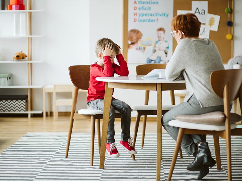 Woman sitting down talking to an upset child