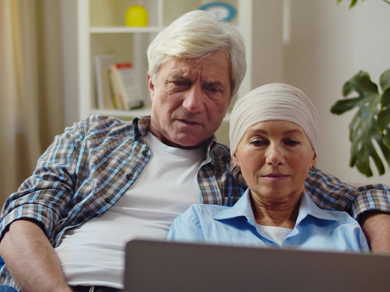 Elderly husband and wife looking at a computer together