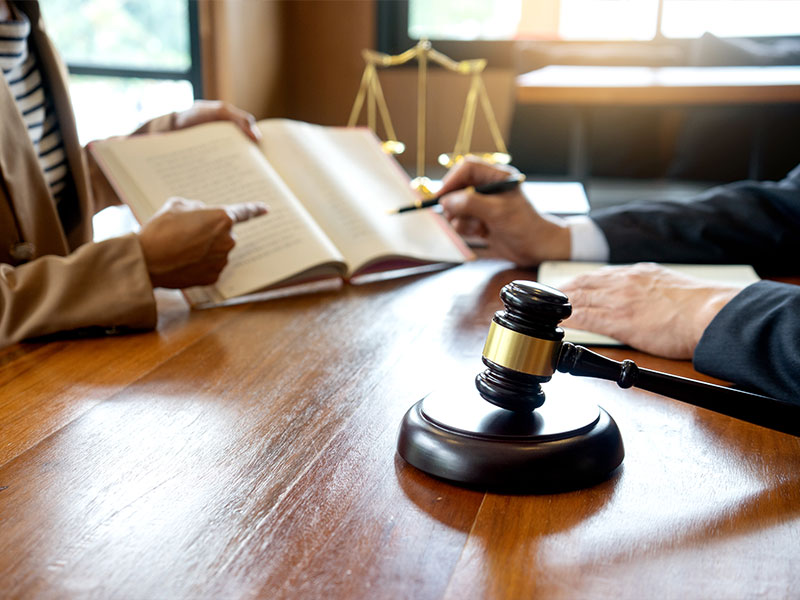 Lawyer pointing at a book a client is holding