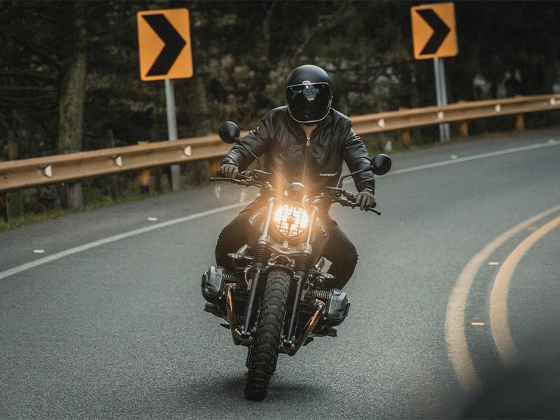 man riding a motorcycle wearing protective gear