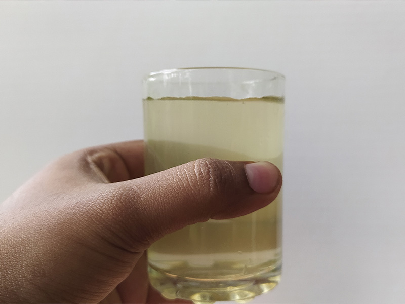 a man holding a glass of contaminated water