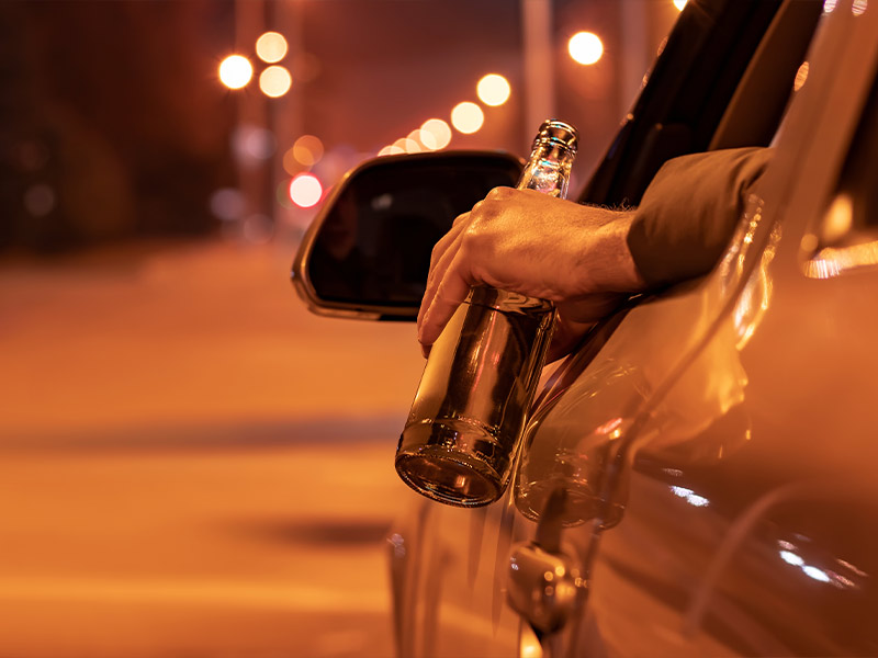 a man driving with a beer in his hand