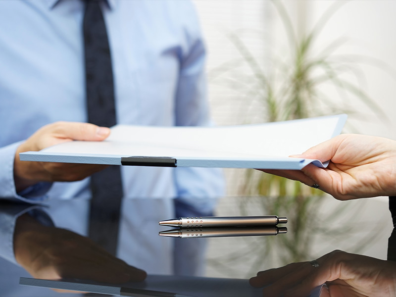 man being handed a stack of paperwork