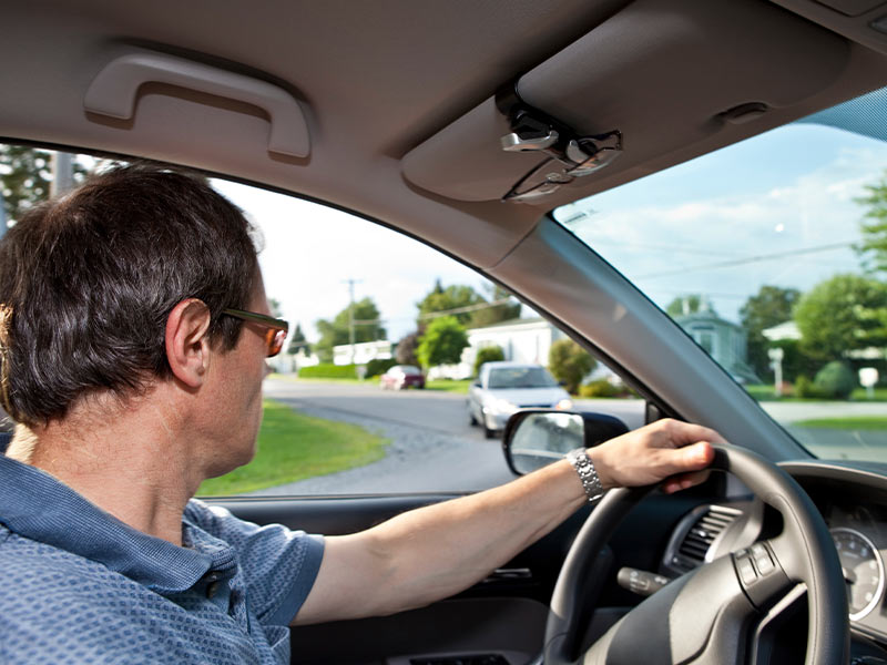 man looking out his window while driving