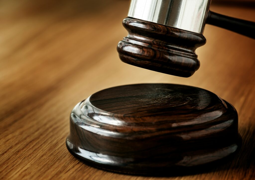 El mazo del juez reposa sobre una mesa de madera, simbolizando la autoridad y el proceso judicial.