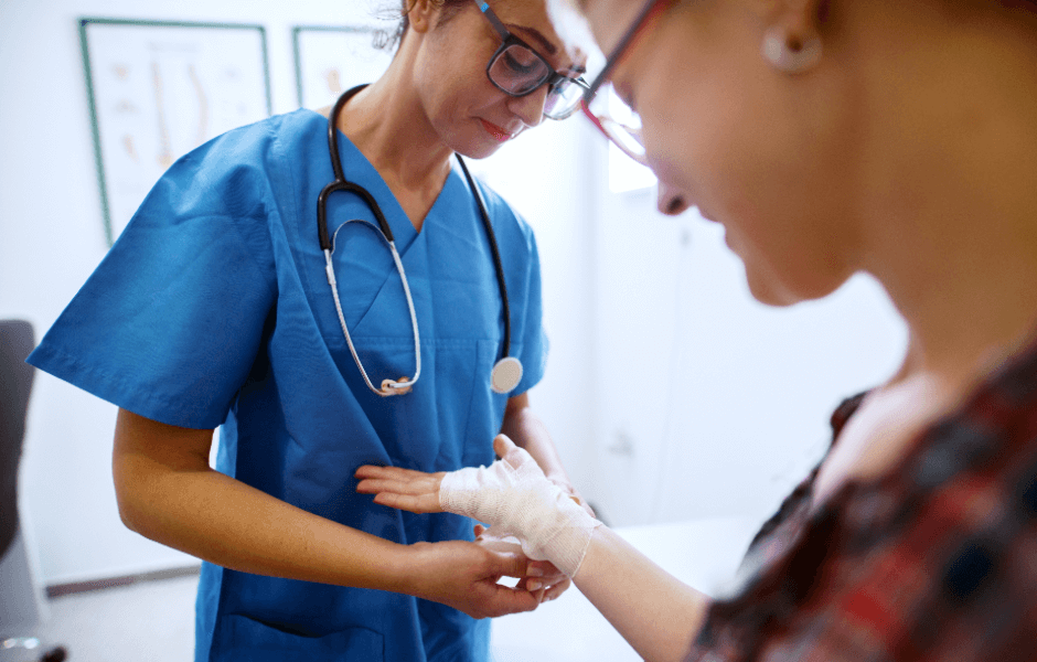 Nurse bandaging a woman's hand