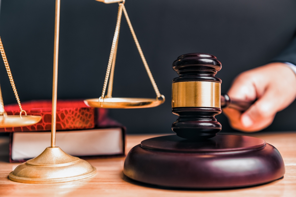 Gavel and scales of justice on a wooden table, symbolizing law and justice concepts.