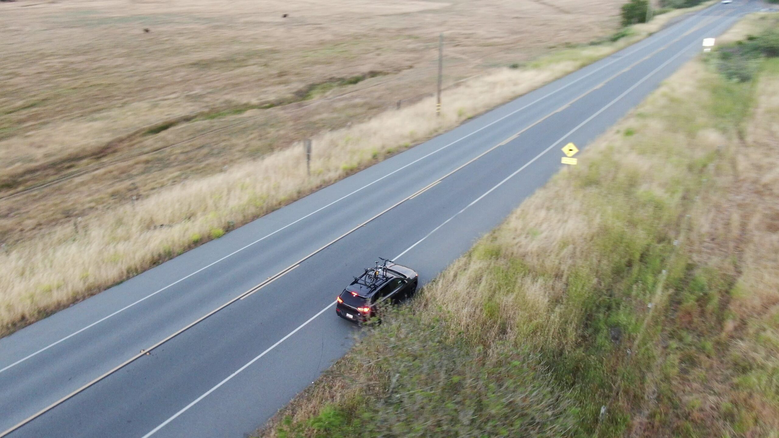 a car sits on the side of an empty road