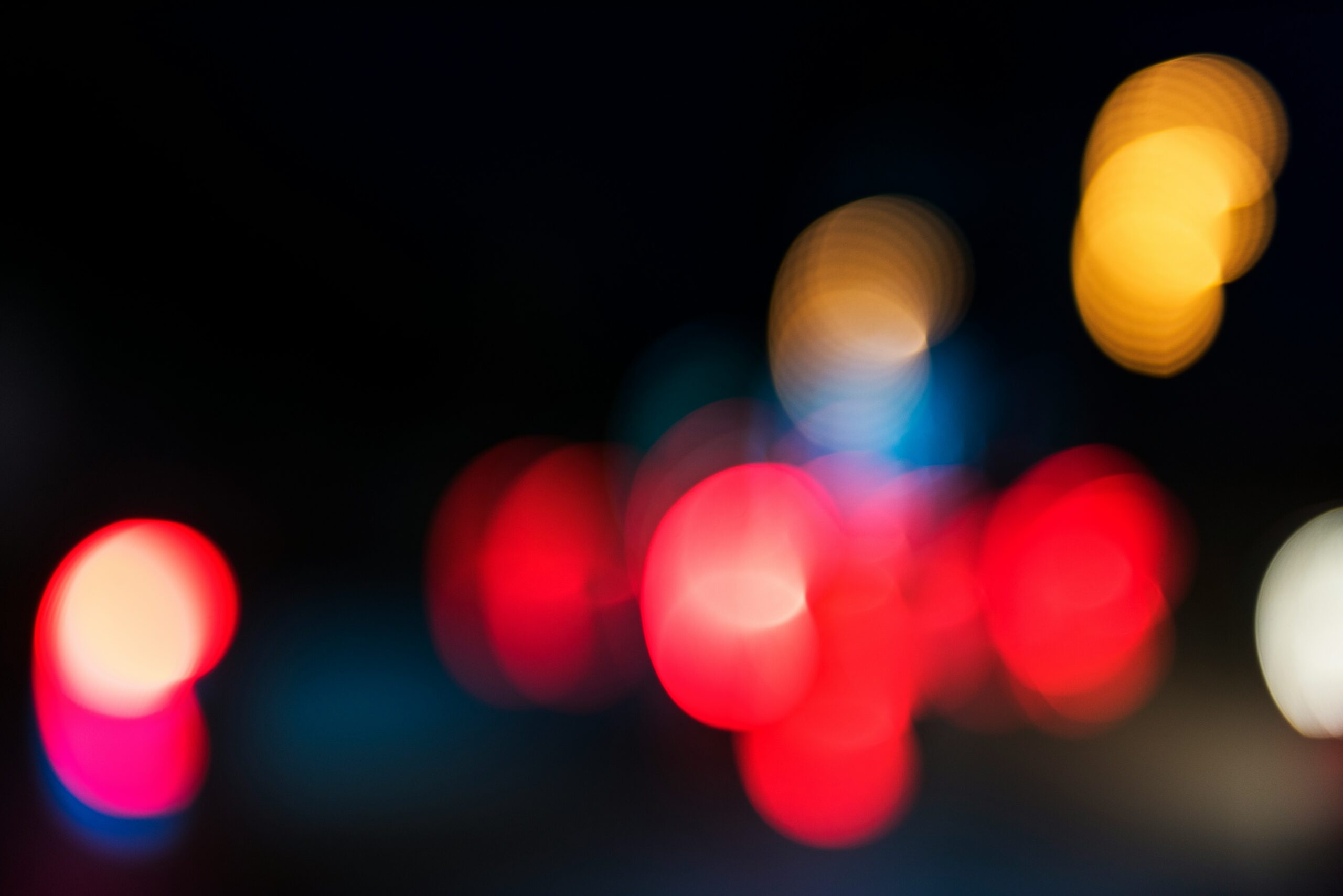blurry red, blue, and white lights at night, indicating a police car