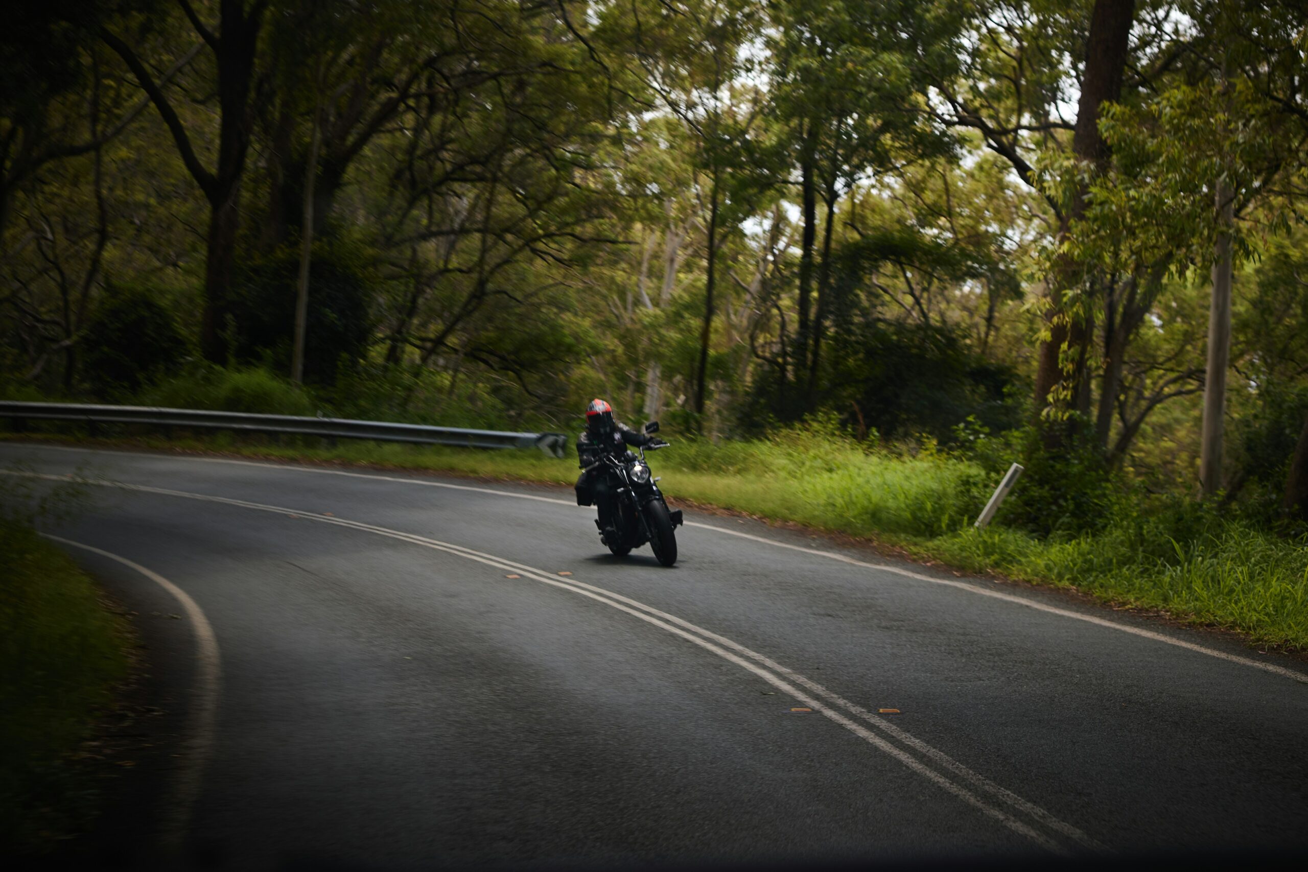 Motorcyclist leaning into a sharp curve on a paved road
